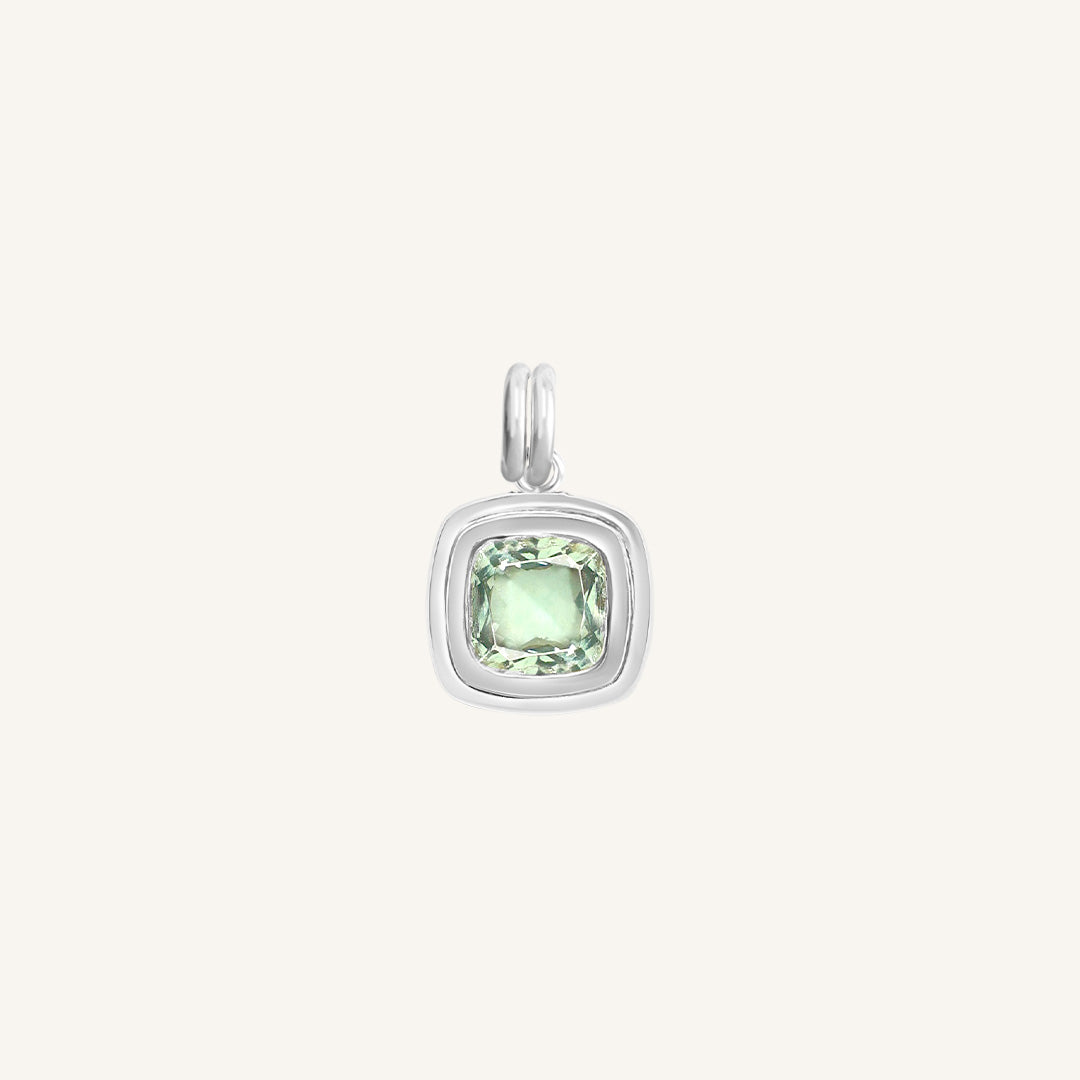 Silver pendant with a green gemstone on a white background