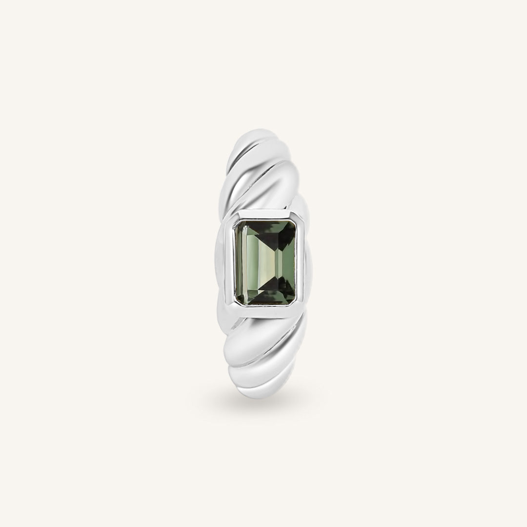 Silver ring with a green gemstone on a white background