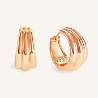 Rose gold hoop earrings on a light beige background