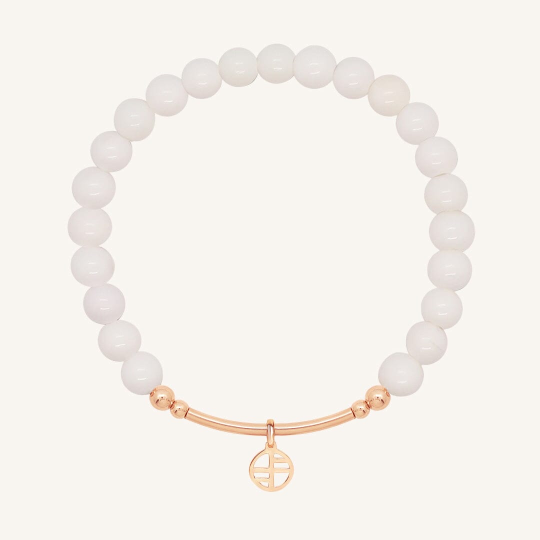 White beaded bracelet with a rose gold clasp on a white background