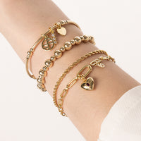 A gold-tone charm bracelet with a beaded design and a charm pendant in the center.