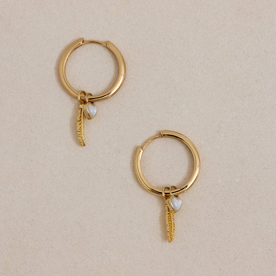 A set of two gold hoop charms with a feather design, on gold hoops
