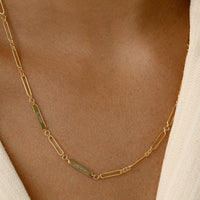 A gold chain necklace with two engraveable panels on a white background