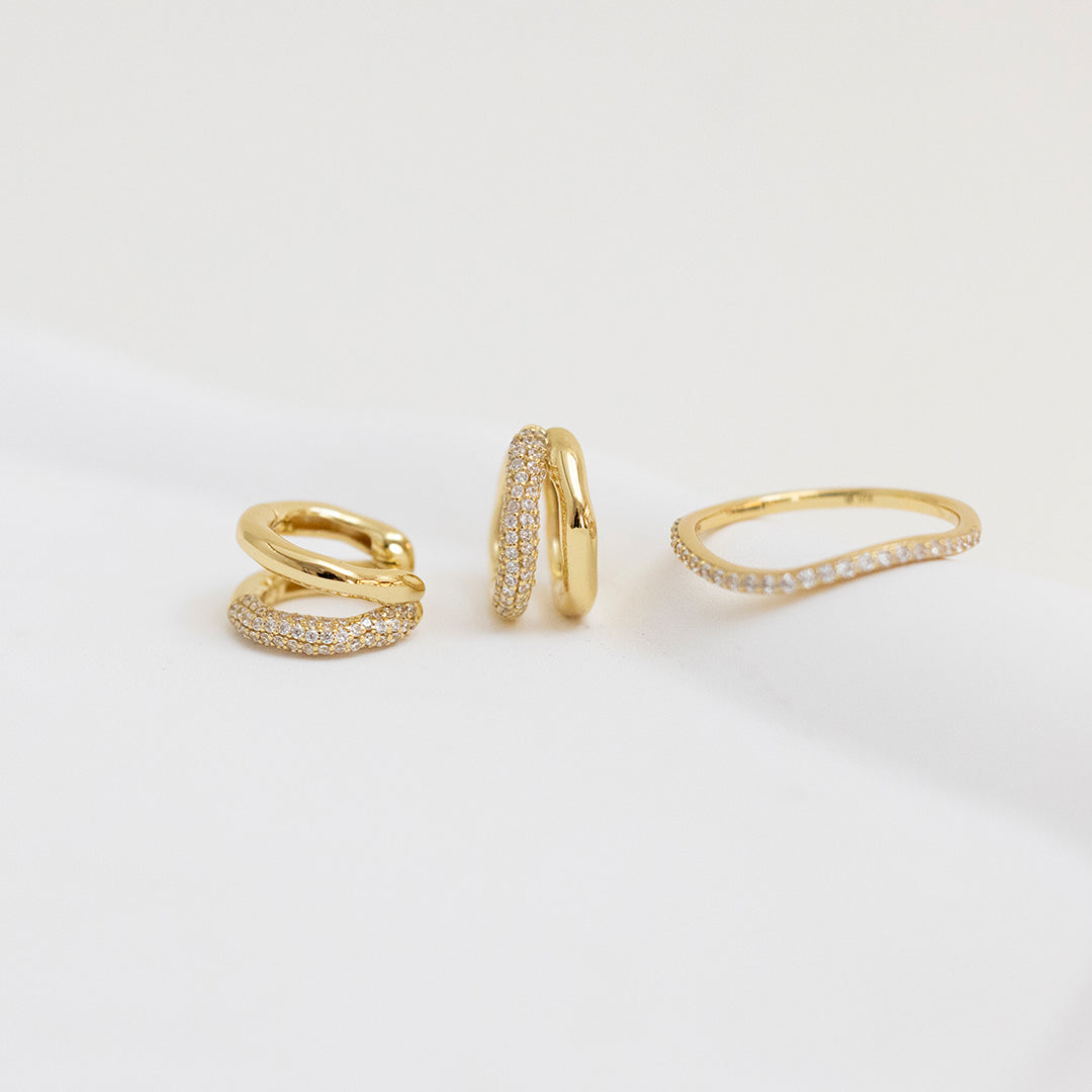 close up shot of gold double huggies with cubic zirconias  with matching ring