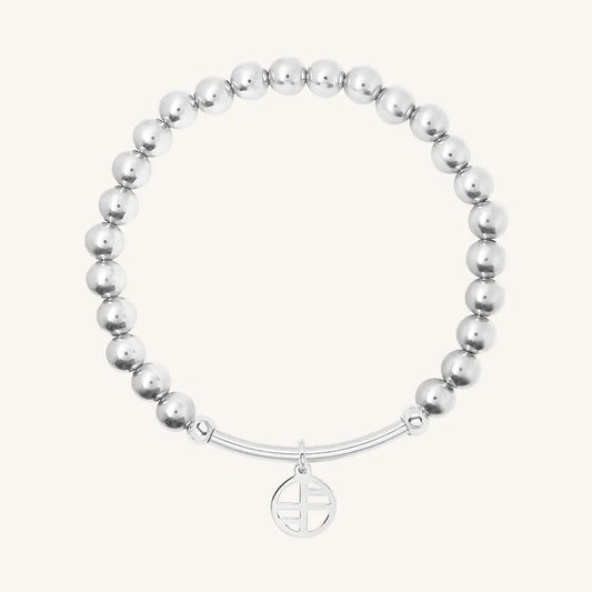 A SILVER-tone charm bracelet with a beaded design and a circular charm hanging from a bar.